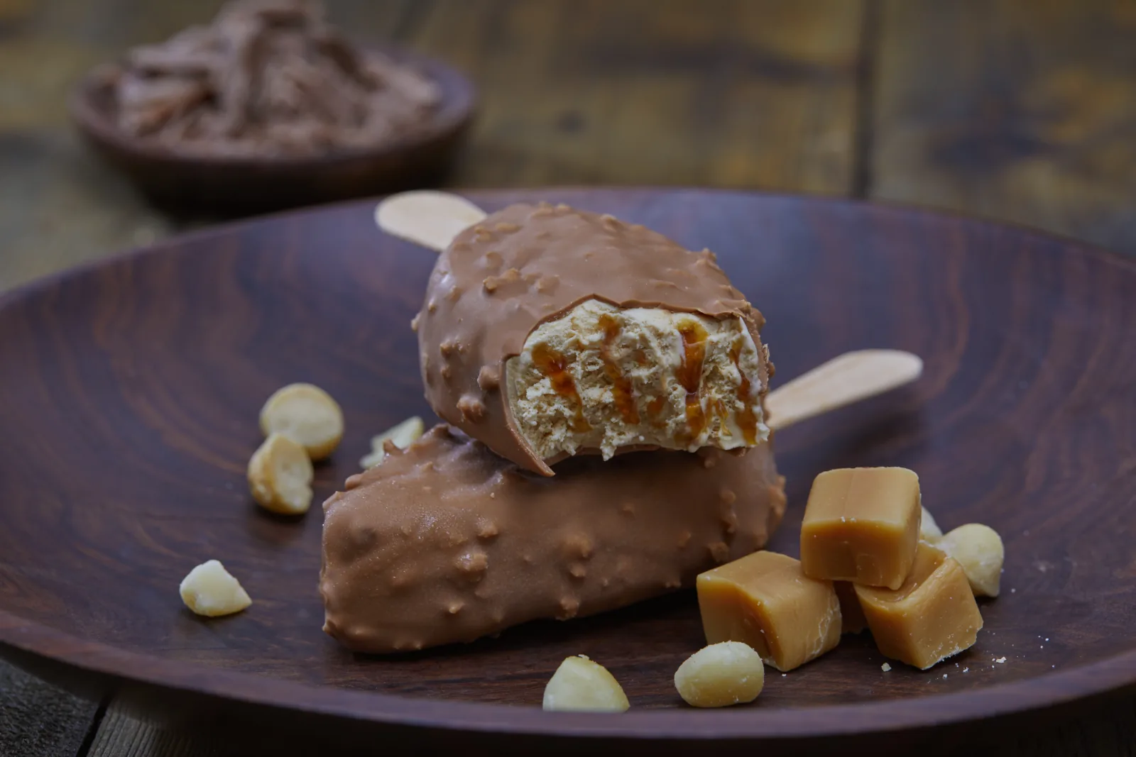 Schokoladen-Eis am Stiel mit Karamellf&uuml;llung und Macadamianuss
