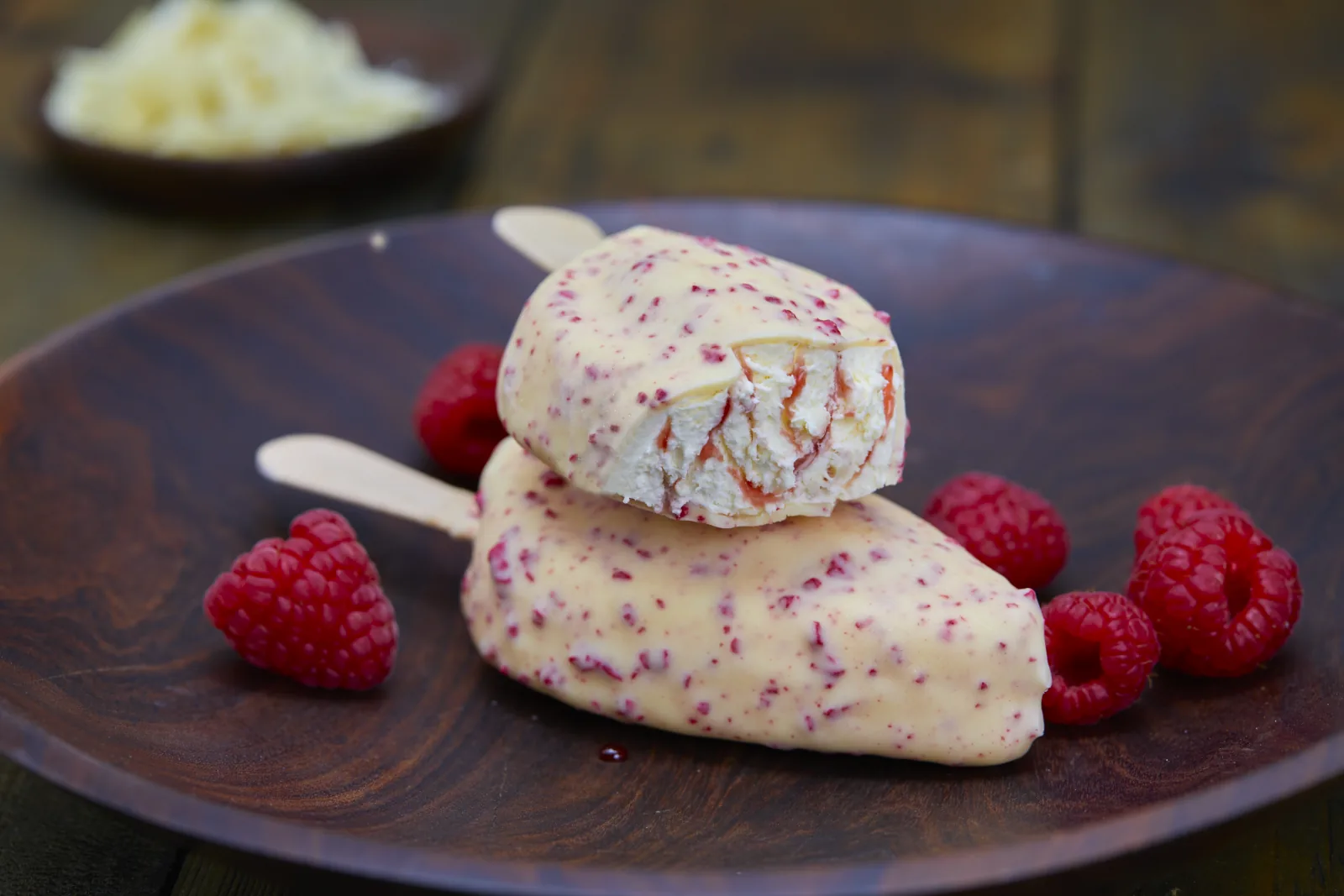 Himbeer-Eis am Stiel mit wei&szlig;er Schokoladenh&uuml;lle und Himbeeren